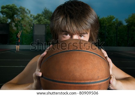 Streetball player with a ball looking straight at camera