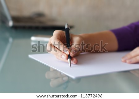 Businesswoman writing with pen