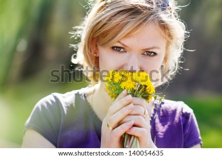 Blonde woman smell dandelion, outdoors