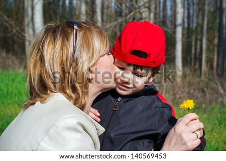 Happy mother hug son with dandelion, outdoor
