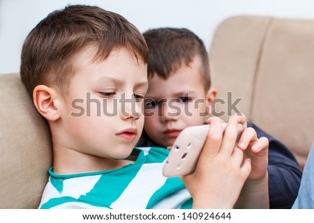 Little boys playing on smartphone Little boys playing on smartphone