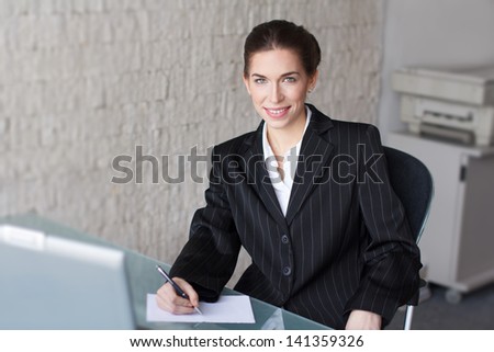 Successful businesswoman with teeth smile in office, signing document
