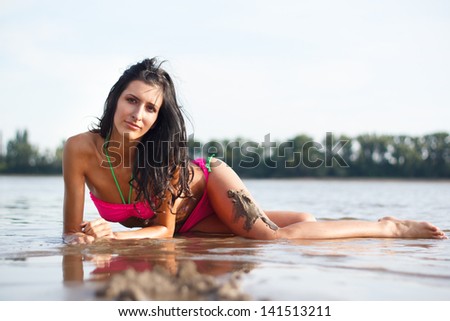 Sexy woman in bikini laying in the water, summer