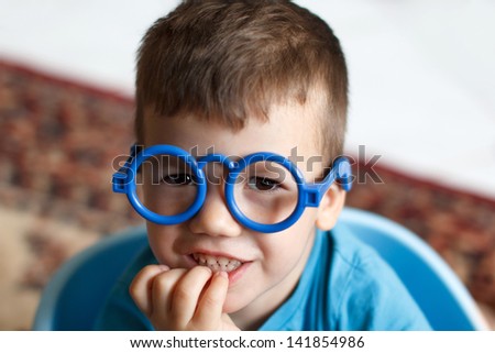 Little cleaver boy in plastic glasses at home, education
