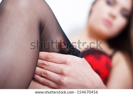 Caucasian brunette woman pull up black stockings