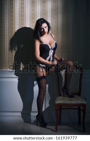 Sexy brunette woman pull down stockings, vintage background