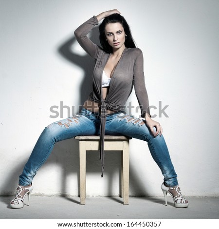 Sexy brunette woman sitting on stool