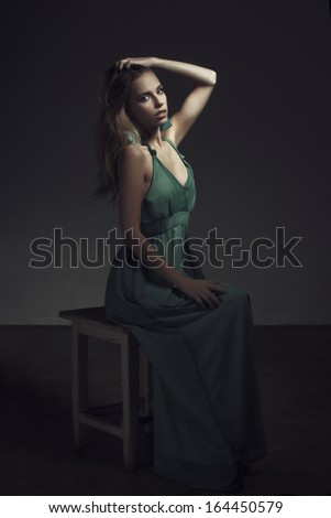 Fashionable woman at night sitting on stool