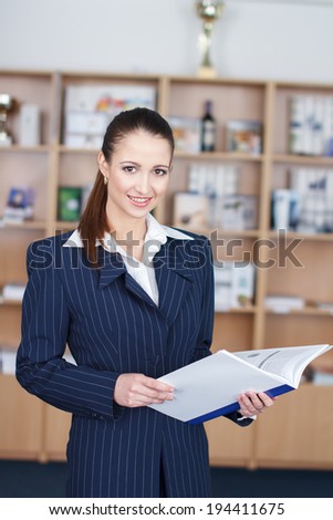 Businesswoman with product catalog teeth smile in office