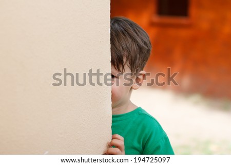 Little boy hide and seek, half face, outdoor