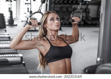 Blonde sexy bodybuilder pulldown practice in gym, back, shoulder and triceps exercise