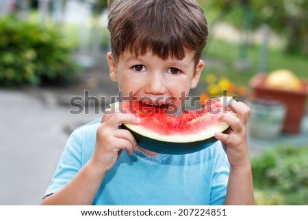 Little cute caucasian boy eat melon, outdoor portrait
