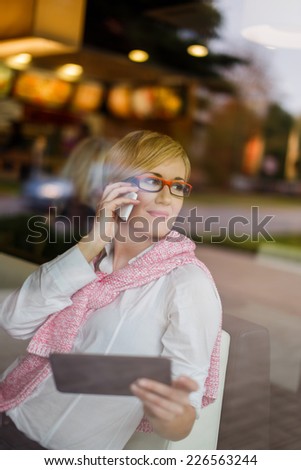 Happy young manager call by smartphone in restaurant, behind glass