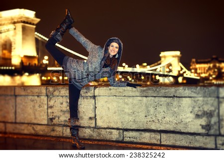 Dynamic woman posing in Budapest, Szechenyi chain bridge, travel, Hungary, vintage style.