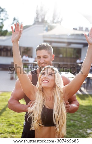 Man help woman get on horizontal bar, outdoor