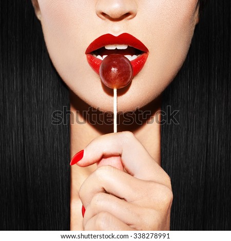 Sexy woman with red lips holding lollipop, beauty closeup