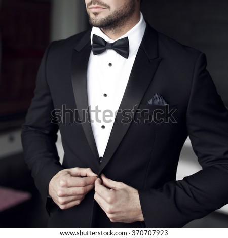 Sexy man in tuxedo and bow tie posing