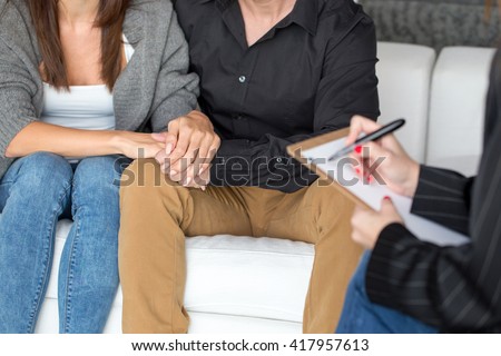 Young couple with a problem to consult a psychologist closeup, therapy, holding each other hand