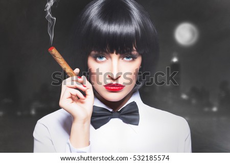 Sexy mafiosi woman boss in tux smoke with cigar in town