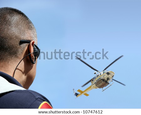 Security agent coordinating surveillance with helicopter