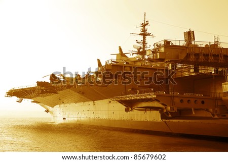 Aircraft carrier in the ocean at sunset