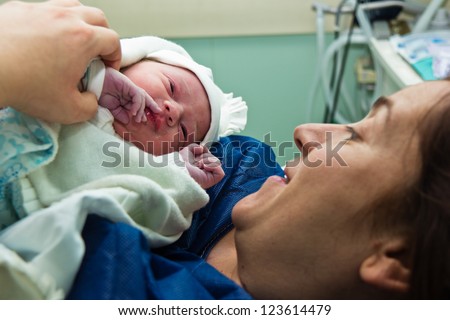 Mother holds her baby at the hospital right after delivery