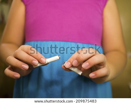 Cigarette being broken in two pieces by hands stop smoking stop addiction