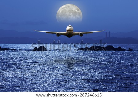 airplane fly above ocean under moonlight