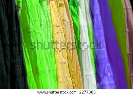 Rainbow of silk skirts on a rack; differential focus