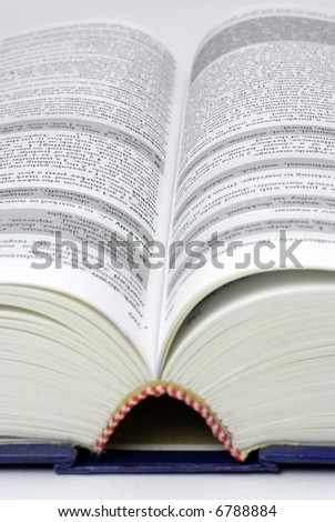 text/reference book lying open; text mostly illegible due to differential focus