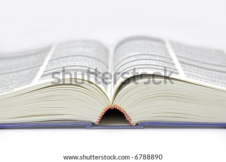 text/reference book lying open; text mostly illegible due to differential focus