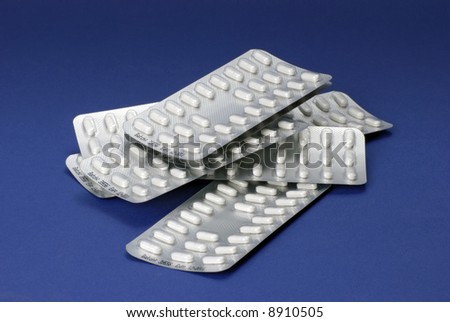 white tablets in heap of blister packs; differential focus
