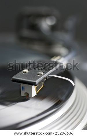 close-up of record player tone arm, pick-up cartridge and stylus; differential focus
