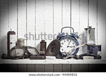 shelf of junk in shed; \'antique\'-style lighting and vignette; subdued color; good copy-space