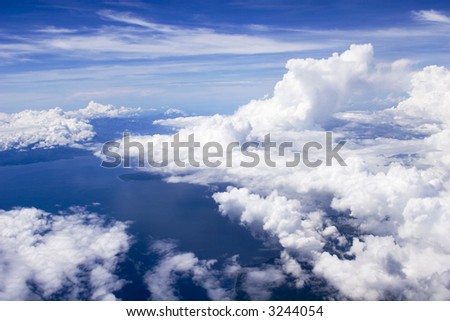 aerial shot of the sky, clouds, earth and the ocean