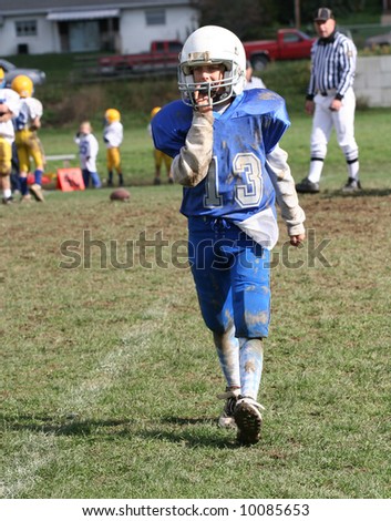 Youth Football Player Walking Off Field During Game.