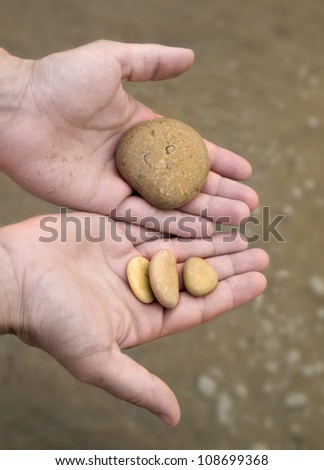 sea stones in hands on the beach