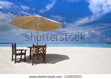 sun shade with two chairs at the beach