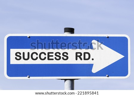 blue and white one-way street sign on a metal mast in front of the blue sky. Success Road is written on the white arrow. Business concept for success and motivation.