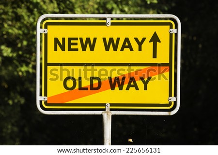 Blue sky behind a yellow city limit or place name sign informing with an arrow that you are on the new way and leaving the old way