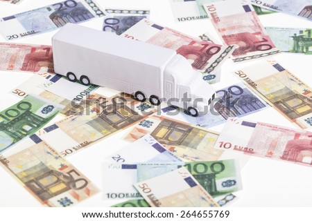 white background with a toy truck on euro banknotes. financial concept for logistics and transportation costs or savings