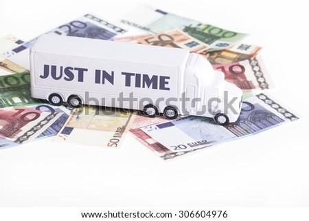 white toy truck with the words just in time placed on euro banknotes. Financial and logistics concept