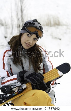 Girl with a ski in ski suits and masks in the snow