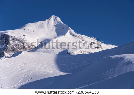 Hintertux Glacier, north summit of Gefrorenen-Wand-Spitzen, gondola cable cars, ski pistes and traces at sunset light. Hintertux ski resort in Zillertal Alps, Tirol, Austria