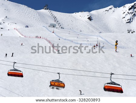 Skiers, orange chairlift and slalom course in Alpine ski resort in Solden in Otztal Alps, Tirol, Austria
