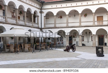 Courtyard in Niepolomice castle near Krakow, Poland, with an outdoor restaurant and cannon