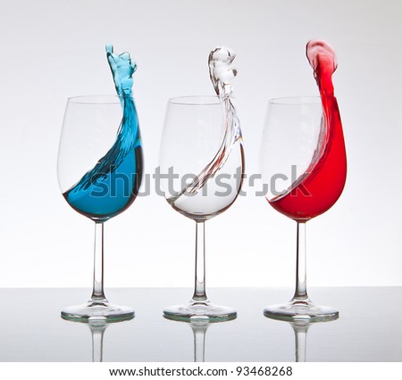 French wine, three Wine Glasses filled with Red, White and Blue colored liquid, then jolted to splash up the sides in perfect synchronization.