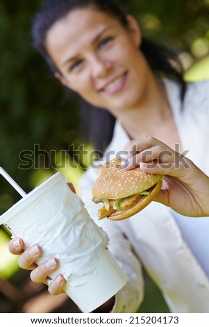 woman eating hamburger and cocktail