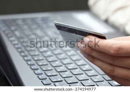 woman holding credit card on laptop for online shopping concep