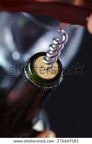 man opening a bottle of wine